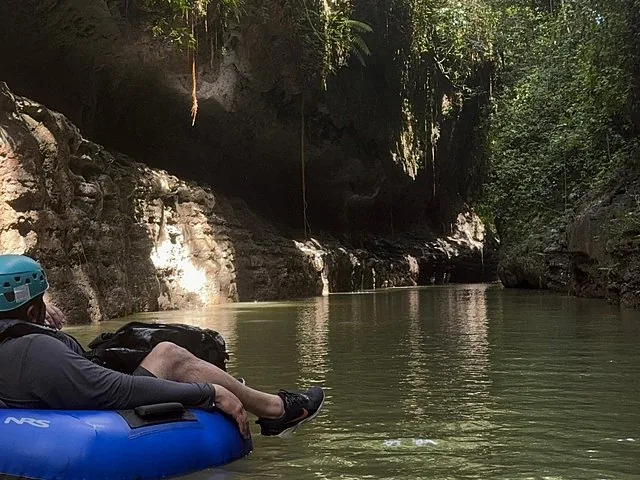 Persona che galleggia su una camera d'aria blu in un fiume